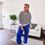 Lightweight black and cream striped crewneck sweater with royal blue contrast stripes at the shoulders, cuffs and hem.