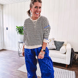 Lightweight black and cream striped crewneck sweater with royal blue contrast stripes at the shoulders, cuffs and hem.