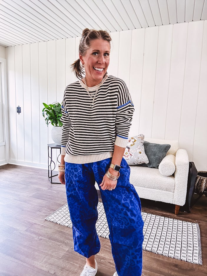 Lightweight black and cream striped crewneck sweater with royal blue contrast stripes at the shoulders, cuffs and hem.