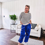 Lightweight black and cream striped crewneck sweater with royal blue contrast stripes at the shoulders, cuffs and hem.