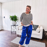 Lightweight black and cream striped crewneck sweater with royal blue contrast stripes at the shoulders, cuffs and hem.