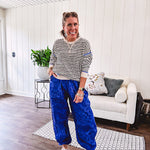 Lightweight black and cream striped crewneck sweater with royal blue contrast stripes at the shoulders, cuffs and hem.