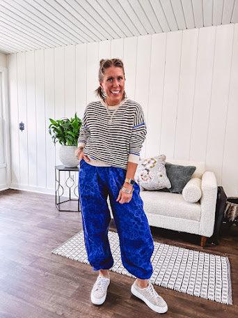 Lightweight black and cream striped crewneck sweater with royal blue contrast stripes at the shoulders, cuffs and hem.