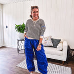 Lightweight black and cream striped crewneck sweater with royal blue contrast stripes at the shoulders, cuffs and hem.