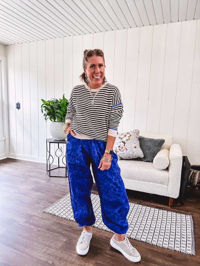 Lightweight black and cream striped crewneck sweater with royal blue contrast stripes at the shoulders, cuffs and hem.