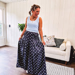 Thin, lightweight ultra wide leg pants in dark denim shade with light blue polka dots throughout and elastic waist with ruffles on the waist and front pockets.