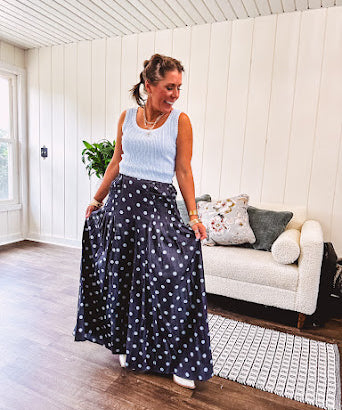 Thin, lightweight ultra wide leg pants in dark denim shade with light blue polka dots throughout and elastic waist with ruffles on the waist and front pockets.