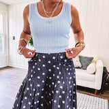Thin, lightweight ultra wide leg pants in dark denim shade with light blue polka dots throughout and elastic waist with ruffles on the waist and front pockets.