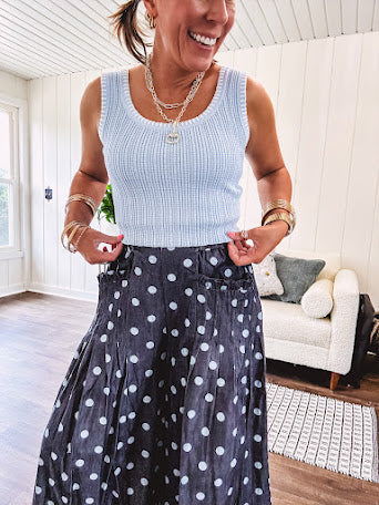 Thin, lightweight ultra wide leg pants in dark denim shade with light blue polka dots throughout and elastic waist with ruffles on the waist and front pockets.