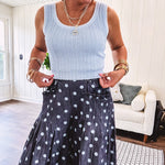 Thin, lightweight ultra wide leg pants in dark denim shade with light blue polka dots throughout and elastic waist with ruffles on the waist and front pockets.