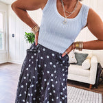 Thin, lightweight ultra wide leg pants in dark denim shade with light blue polka dots throughout and elastic waist with ruffles on the waist and front pockets.