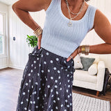 Thin, lightweight ultra wide leg pants in dark denim shade with light blue polka dots throughout and elastic waist with ruffles on the waist and front pockets.