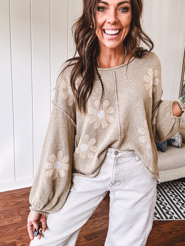Soft, lightweight, nearly sheer knit pullover  with long sleeves, exposed seams at the shoulders and down the center with large daisy florals throughout. Available in multiple colors.