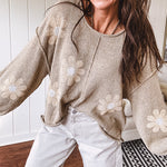 Soft, lightweight, nearly sheer knit pullover  with long sleeves, exposed seams at the shoulders and down the center with large daisy florals throughout. Available in multiple colors.