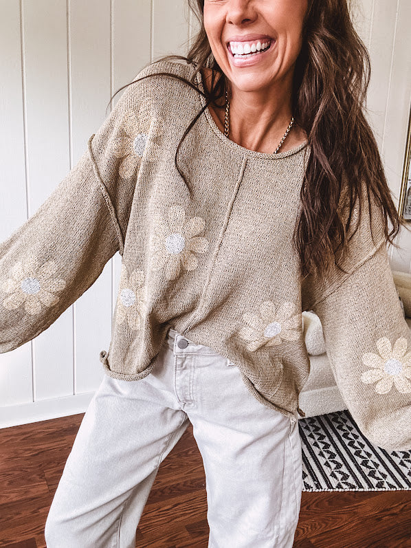 Soft, lightweight, nearly sheer knit pullover  with long sleeves, exposed seams at the shoulders and down the center with large daisy florals throughout. Available in multiple colors.