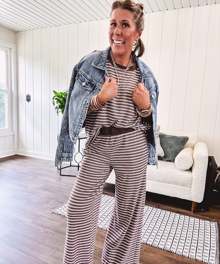 Medium wash non-stretch denim jacket with classic trim, raw, uneven hem and cuffs with silver hardware and cropped length.