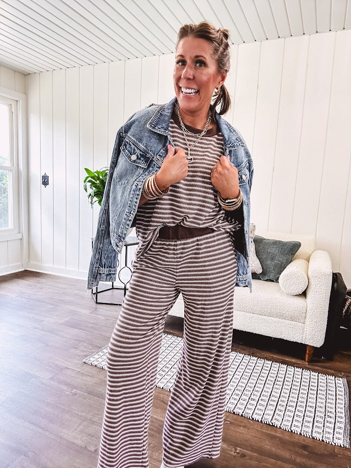 Medium wash non-stretch denim jacket with classic trim, raw, uneven hem and cuffs with silver hardware and cropped length.