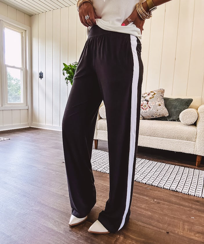 Buttery soft black lounge pants with white striping down the sides and elastic waist with pleated front.