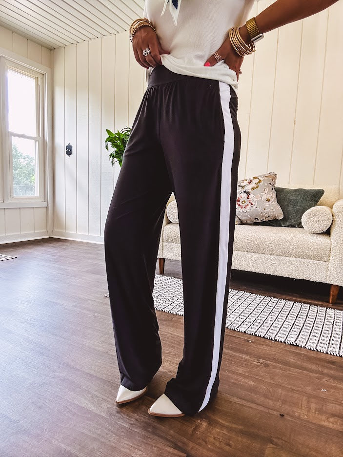 Buttery soft black lounge pants with white striping down the sides and elastic waist with pleated front.