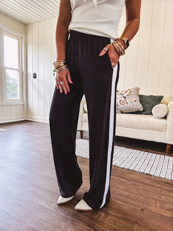 Buttery soft black lounge pants with white striping down the sides and elastic waist with pleated front.