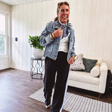 Medium wash non-stretch denim jacket with classic trim, raw, uneven hem and cuffs with silver hardware and cropped length.