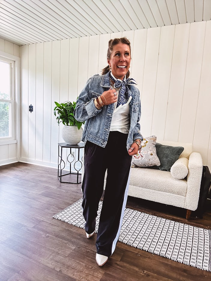 Medium wash non-stretch denim jacket with classic trim, raw, uneven hem and cuffs with silver hardware and cropped length.
