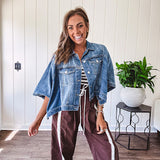 Medium wash denim cape jacket with seam detail, collar and silver buttons down the front and on the front pockets.