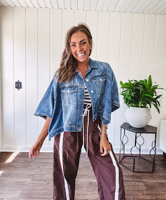 Medium wash denim cape jacket with seam detail, collar and silver buttons down the front and on the front pockets.