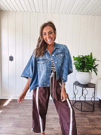 Medium wash denim cape jacket with seam detail, collar and silver buttons down the front and on the front pockets.
