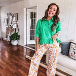 Cotton button and zipper closure bright floral pants with seams down the front of both legs and front and back 