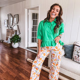 Cotton button and zipper closure bright floral pants with seams down the front of both legs and front and back 