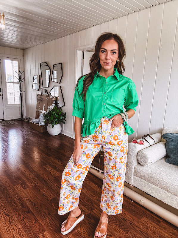 Cotton button and zipper closure bright floral pants with seams down the front of both legs and front and back 