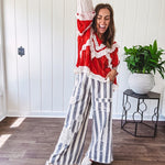 Apple red ruffle texture boho style long sleeved top with round neck and cream eyelet lace detail in a V shape across the front and on the sleeves and hem.
