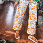 Cotton button and zipper closure bright floral pants with seams down the front of both legs and front and back 