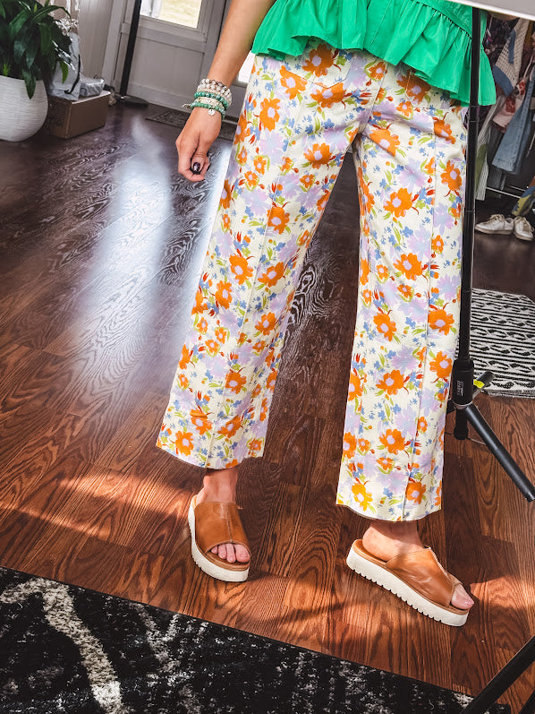 Cotton button and zipper closure bright floral pants with seams down the front of both legs and front and back 