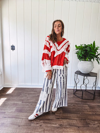 Wide leg cotton oversized gray and white striped pants with elastic back, button and zipper closure and crochet patch detail throughout.