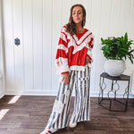Apple red ruffle texture boho style long sleeved top with round neck and cream eyelet lace detail in a V shape across the front and on the sleeves and hem.