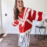 Apple red ruffle texture boho style long sleeved top with round neck and cream eyelet lace detail in a V shape across the front and on the sleeves and hem.