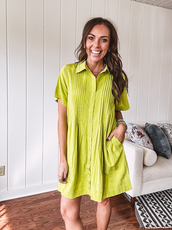 Chartreuse short sleeved button down dress, mini length with pintuck detail in front and pockets.