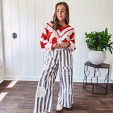 Wide leg cotton oversized gray and white striped pants with elastic back, button and zipper closure and crochet patch detail throughout.