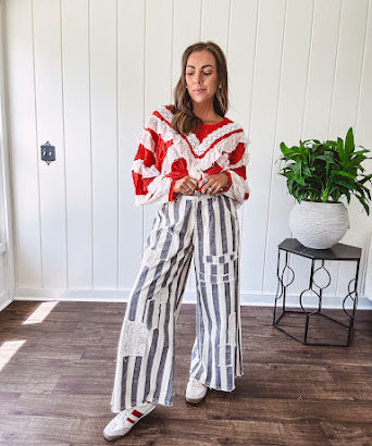 Wide leg cotton oversized gray and white striped pants with elastic back, button and zipper closure and crochet patch detail throughout.
