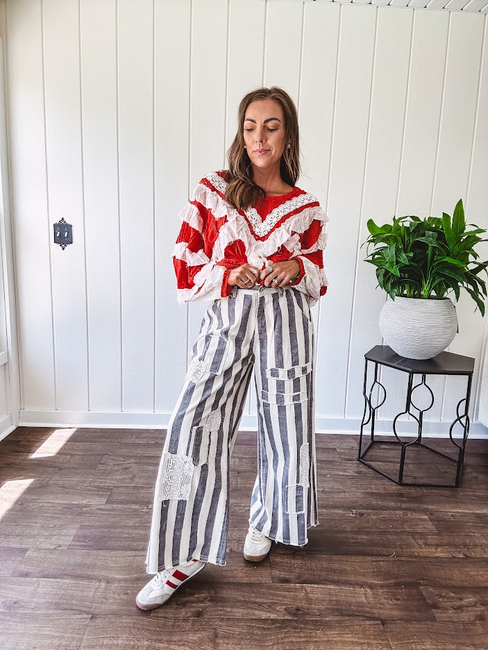 Wide leg cotton oversized gray and white striped pants with elastic back, button and zipper closure and crochet patch detail throughout.
