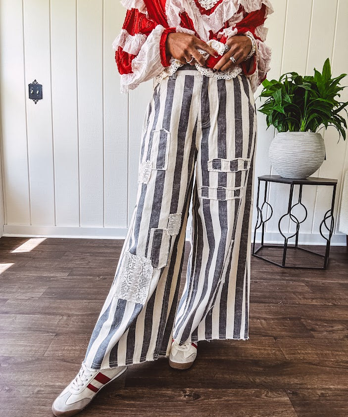 Wide leg cotton oversized gray and white striped pants with elastic back, button and zipper closure and crochet patch detail throughout.