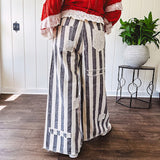 Wide leg cotton oversized gray and white striped pants with elastic back, button and zipper closure and crochet patch detail throughout.