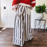 Wide leg cotton oversized gray and white striped pants with elastic back, button and zipper closure and crochet patch detail throughout.