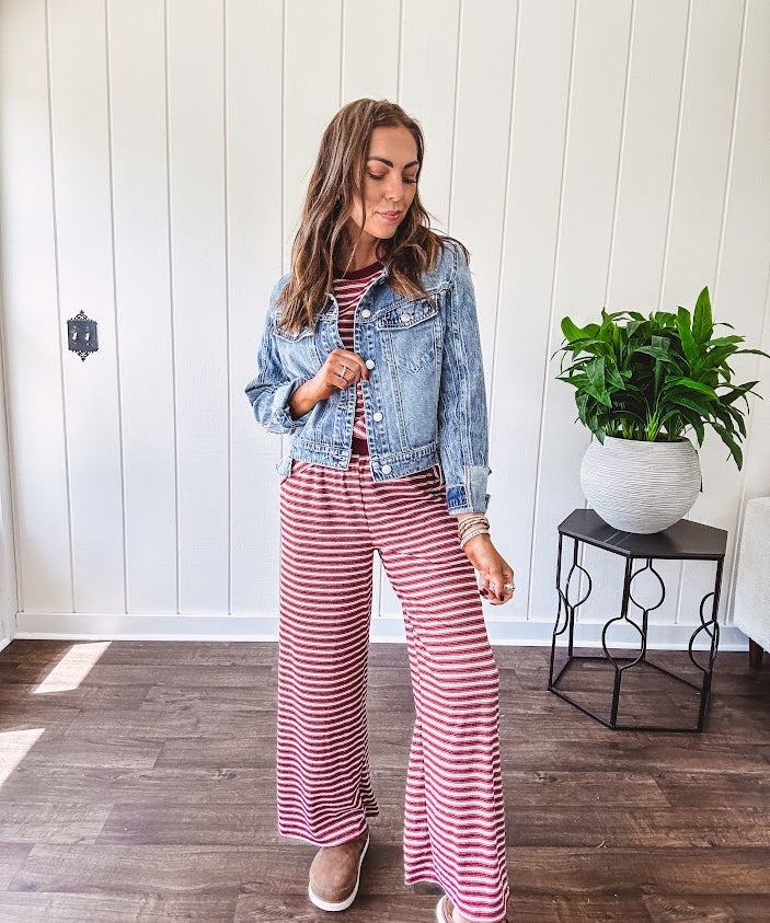 Medium wash non-stretch denim jacket with classic trim, raw, uneven hem and cuffs with silver hardware and cropped length.