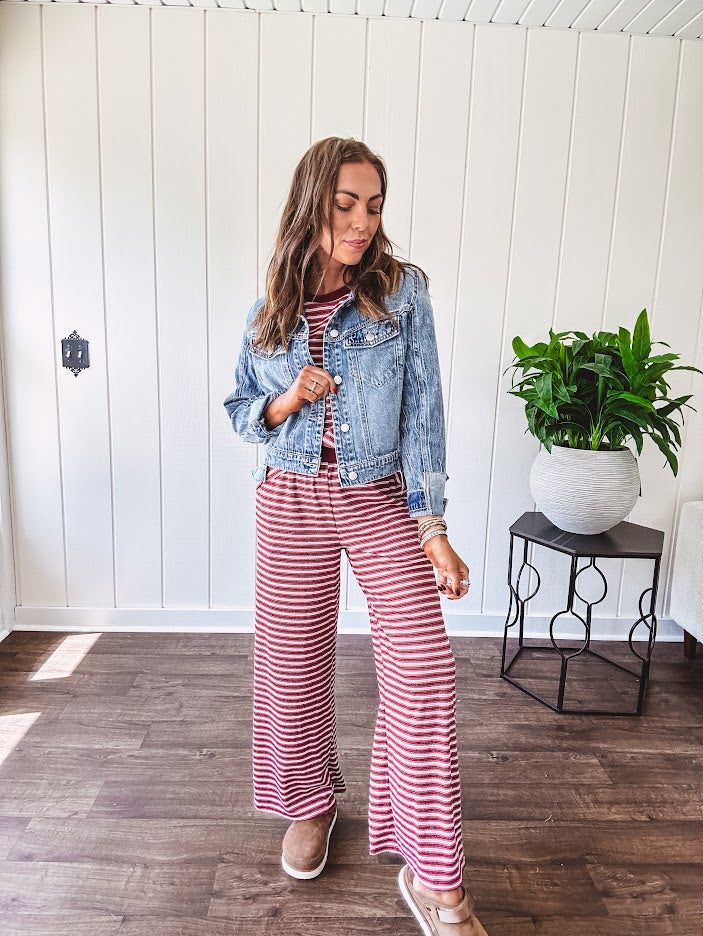 Medium wash non-stretch denim jacket with classic trim, raw, uneven hem and cuffs with silver hardware and cropped length.