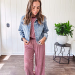 Medium wash non-stretch denim jacket with classic trim, raw, uneven hem and cuffs with silver hardware and cropped length.