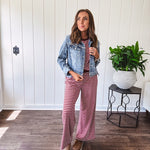 Medium wash non-stretch denim jacket with classic trim, raw, uneven hem and cuffs with silver hardware and cropped length.