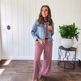 Medium wash non-stretch denim jacket with classic trim, raw, uneven hem and cuffs with silver hardware and cropped length.